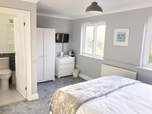 a bedroom with a bed and a toilet and window at Olcote House in Padstow