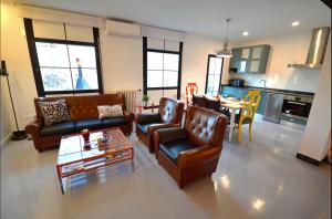 a living room with couches and a table and a kitchen at Ohana Apartamento Rural in Malón