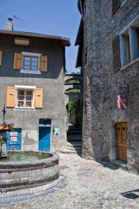 un edificio de piedra con una ventana en el lateral. en Au Cheval Blanc - appartements et chambres d'hôtes en Albertville