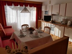 a kitchen with a table with a white table cloth at Appartmenthotel Residence Elvis in Ortisei