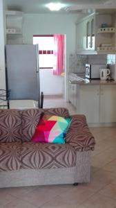 a room with a couch with a colorful blanket on it at Residences Abrico in Mont Choisy +7 photos