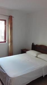 a white bed in a bedroom with a window at Residences Abrico in Mont Choisy
