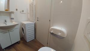 a white bathroom with a toilet and a sink at Decanska Apartments in Belgrade