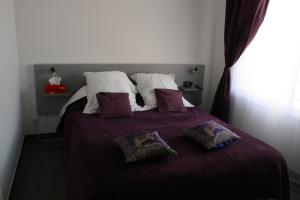 a bedroom with a bed with purple sheets and pillows at Casa Oliva -situé au 2ème étage sans ascenseur in Perpignan