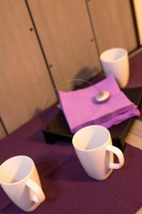 a table with two cups on a purple table at Poarta Schei apartment in Braşov