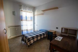 a small bedroom with a bed and a table at Terrazza di Pinerolo in Pinerolo