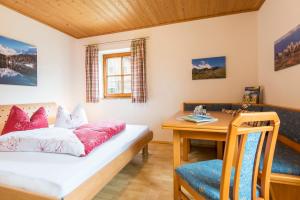 Zimmer mit einem Tisch, einem Bett und einem Schreibtisch in der Unterkunft Biohof Maurachgut in Bad Hofgastein