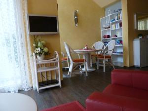 salon ze stołem, krzesłami i telewizorem w obiekcie Villa Patricia w mieście Kühlungsborn