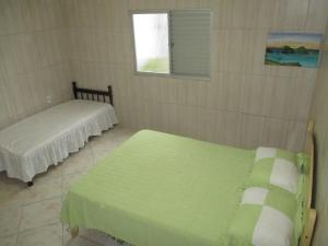 a room with two beds and a window at Morada da Rose in Pinheira