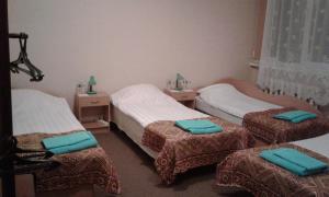 a room with three beds with blue pillows on them at Viesu māja Ezerkalns in Krāslava