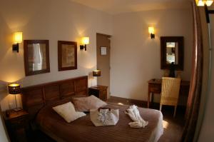 1 dormitorio con 1 cama grande y 2 lámparas en Logis Hôtel Le Cheval Noir, en Argenton-sur-Creuse
