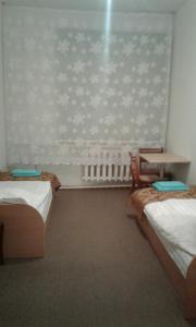 a room with two beds and a table in it at Viesu māja Ezerkalns in Krāslava