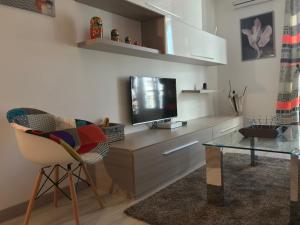 een woonkamer met een tv en een stoel en een tafel bij Candille in Nice