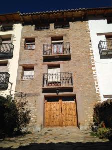 バルデリナレスにあるCasa Inésの大きなレンガ造りの建物で、2つのドアと2つのバルコニーが付いています。