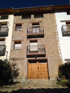 a large brick building with two doors and two balconies at Casa Inés in Valdelinares