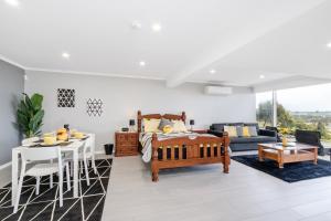 a living room with a bed and a couch at Views Forever - Devonport in Devonport