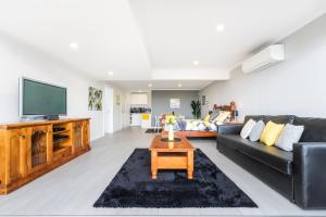 a living room with a couch and a tv at Views Forever - Devonport in Devonport