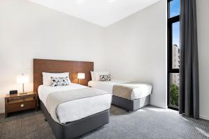 a hotel room with two beds and a window at Melbourne CBD Central Apartment Hotel Official in Melbourne