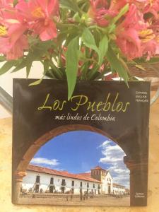 a book sitting on a table with flowers at Casas del Viento in Villa de Leyva