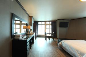 Habitación de hotel con cama, escritorio, cama y habitación en Benikea Hotel Mountain & Ocean Daepohang, en Sokcho