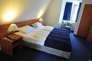 فندق هاوس رايشرت في بادن بادن: غرفة نوم بسرير ومصباح وكرسي