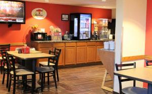 a restaurant with tables and chairs and a counter at Super 8 by Wyndham Kearney in Kearney