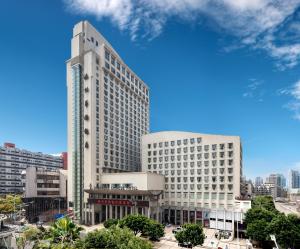 wysoki biały budynek w mieście w obiekcie Overseas Chinese Hotel Wenzhou w mieście Wenzhou