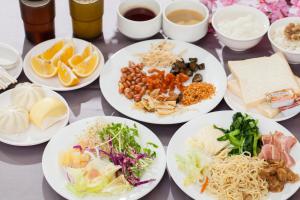 F Hotel - Chiayi في Fanlu: طاولة عليها أطباق من الطعام