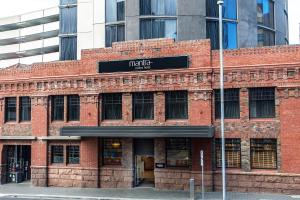 a red brick building with a sign on it at Mantra Collins Hotel in Hobart