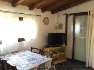 een woonkamer met een tafel en een televisie bij Casa Mare Tamerici in San Teodoro