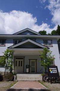 a house with a sign in front of it at Sunny Side Hut in Hakuba