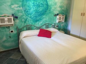 een slaapkamer met een wit bed en een rood kussen bij Casa Mare Tamerici in San Teodoro