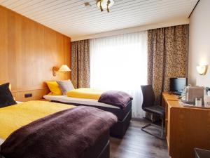 a hotel room with two beds and a window at Hotel-Restaurant Zum Babbelnit in Mainz