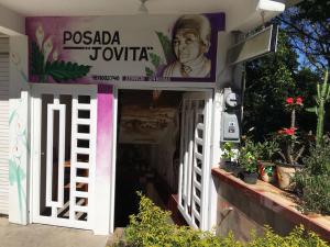 a building with a sign above a doorway with a door at Hotel Jovita in Xilitla