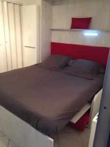 a bedroom with a bed with a red and white headboard at Residence Acapulco in Villeneuve-Loubet