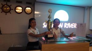 two women standing behind a counter with a trophy at Sai Gon River Hotel in Ho Chi Minh City