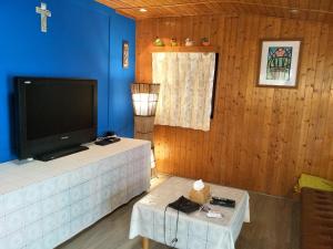 a living room with a tv and a blue wall at Yes, Sir Homestay in Nangan