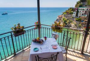 a table on a balcony with a view of the ocean at Hotel Cetus in Cetara
