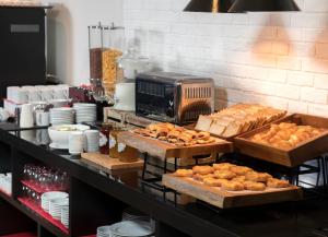 a buffet with bread and pastries on a table at Travelodge Sukhumvit 11 in Bangkok