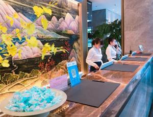 two women standing at a counter with their laptops at The Pearl Boutique Hotel in Yongjia