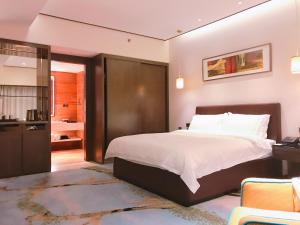 1 Schlafzimmer mit einem großen Bett und einem Badezimmer in der Unterkunft The Pearl Boutique Hotel in Yongjia
