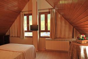 a bedroom with a bed and two windows at Hotel-Aparthotel El Reyno in Sallent de Gállego