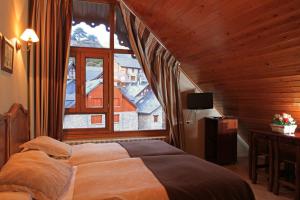 sypialnia z łóżkiem i dużym oknem w obiekcie Hotel-Aparthotel El Reyno w mieście Sallent de Gállego