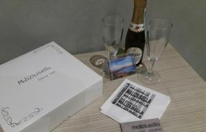 a table with a bottle of champagne and wine glasses at Maliziusella in Naples