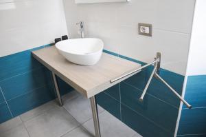un bagno con lavandino a ciotola su un tavolo in legno di Torre Lapillo Centro GMA Tourism a Torre Lapillo Altre 43 foto