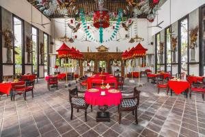 a dining room with red tables and chairs at Hotel Tugu Lombok - CHSE Certified in Tanjung