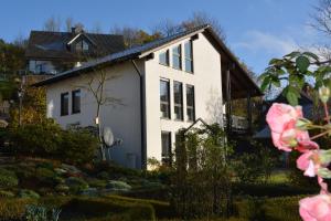 een wit huis met een tuin ervoor bij Ferienwohnung Sonnenkamp in Schmallenberg