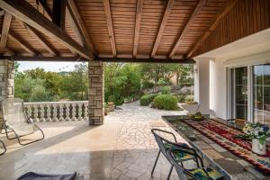 an outdoor patio with a wooden pergola at Lucy in Krk