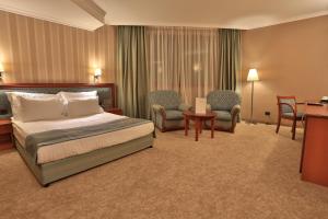 A bed or beds in a room at Marina Residence Boutique Hotel