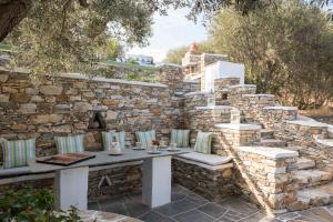 pared de piedra con mesa de piedra y sillas en Rose Home, en Apollonia